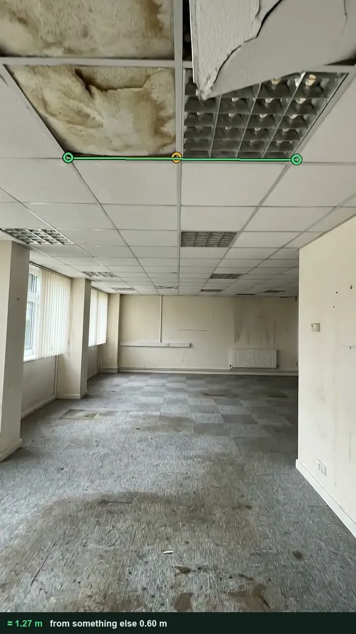 Office ceiling grid with water-stained tiles and a broken tile hanging down, measured against a 600 mm ceiling tile
