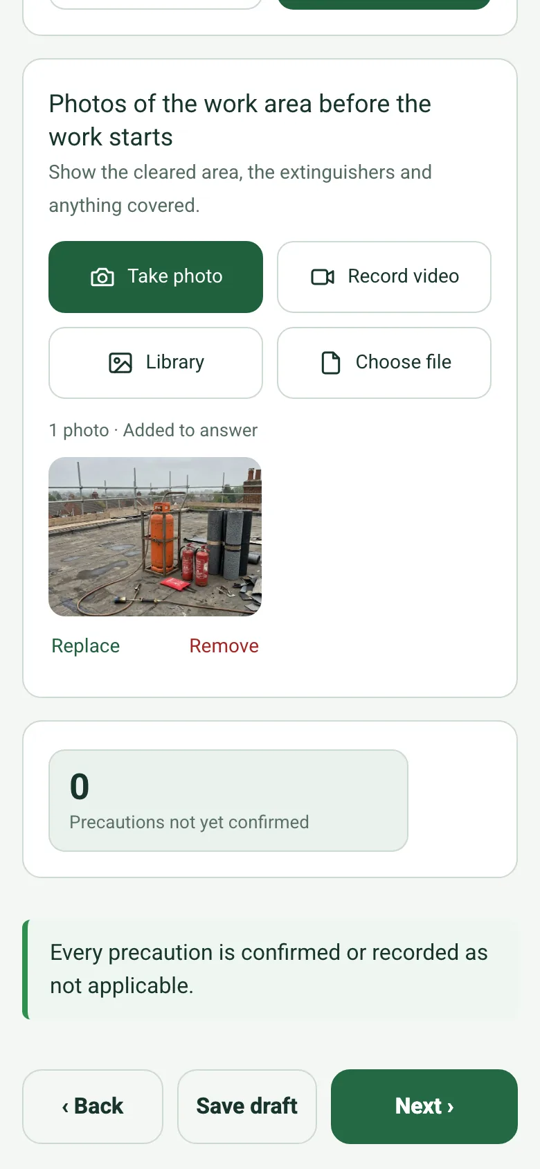 The precautions page of the completed hot works permit on a phone: a photo of the cleared work area, the count Precautions not yet confirmed reading 0 and a green note that every precaution is confirmed