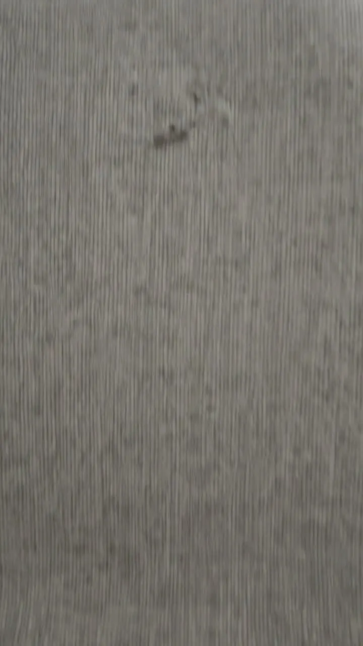 Close-up of grey upholstered dining chair fabric with a dark stain
