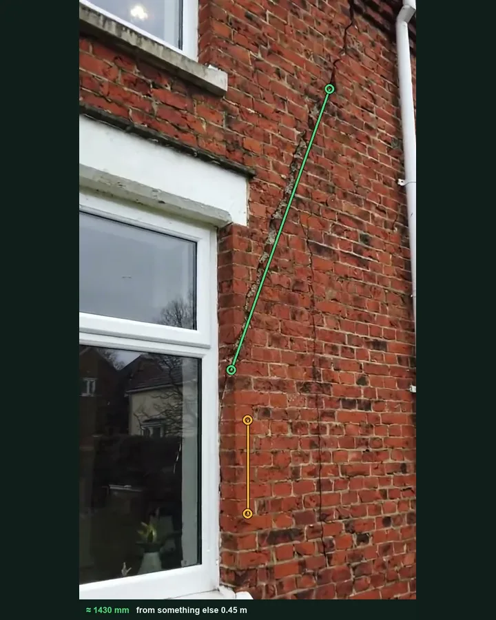 A diagonal crack in a brick rear wall marked with a green measuring line from the window head, against an amber reference of six brick courses, giving about 1430 mm