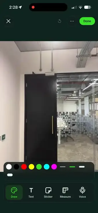 Marking up a site photo in SiteSurvey, drawing a circle round a defect, typing the label 'Door is sticking', measuring the door on the image and recording a spoken note that transcribes itself