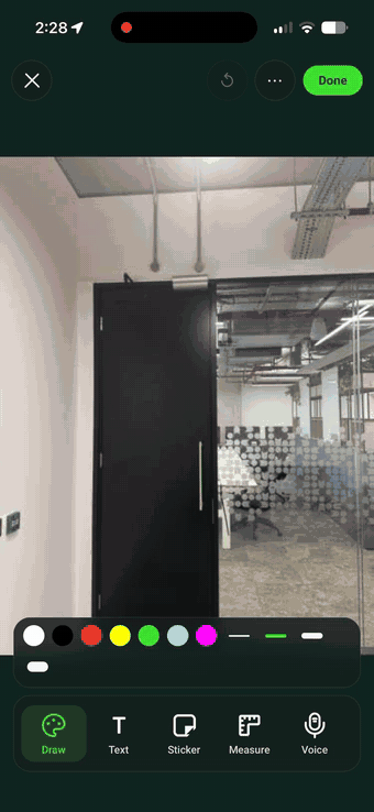 Marking up a site photo in SiteSurvey — drawing a circle round a defect, typing the label 'Door is sticking', measuring the door on the image and recording a spoken note that transcribes itself