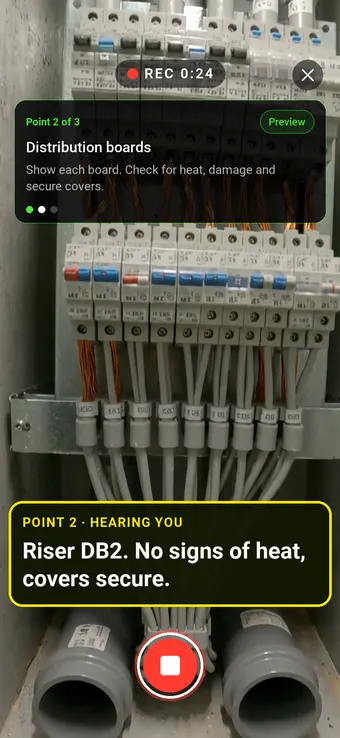 An electrical distribution board in a riser, with the Walk Cam point card and live transcription