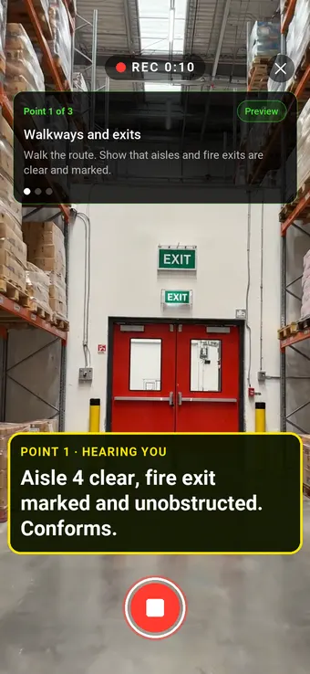Walk Cam on a safety audit: a clear warehouse aisle leading to a marked fire exit, with the point card and the auditor's words transcribed live