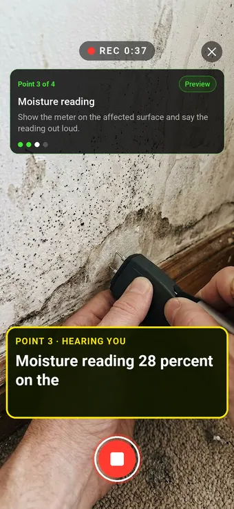 A moisture meter pressed against a mould-stained wall, with the Walk Cam point card and live transcription