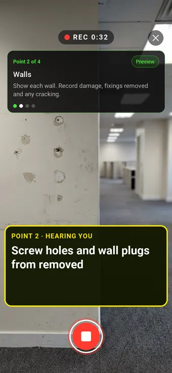 An office wall with screw holes left by removed shelving, with the Walk Cam point card and live transcription