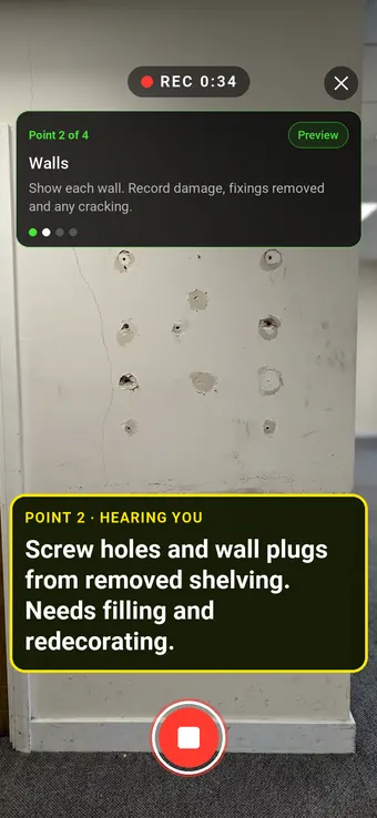 An office wall with screw holes left by removed shelving, with the Walk Cam point card and live transcription