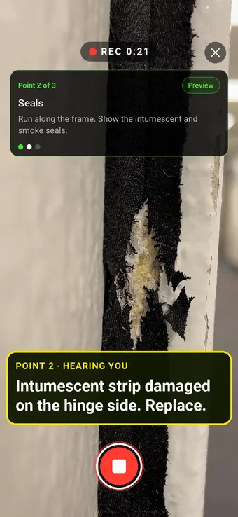 A damaged intumescent strip on a fire door frame, with the Walk Cam point card and live transcription