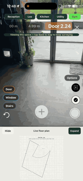 Walking from room to room in augmented reality — each space named along the top, the live floor plan building underneath