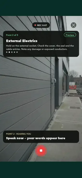 An electrical inspection point in SiteSurvey Walk Cam — filming an external socket while live voice-to-text writes the observation about a smashed cover and exposed conductors
