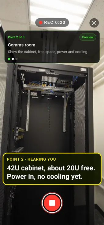 A comms room with an empty network cabinet, with the Walk Cam point card and live transcription
