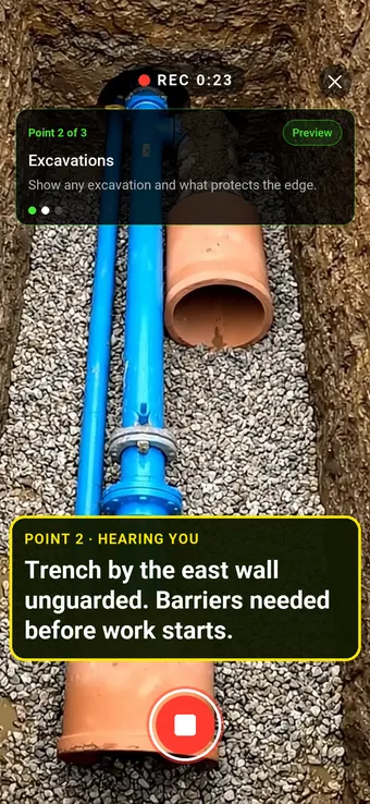 An open excavation trench on a construction site, with the Walk Cam point card and live transcription